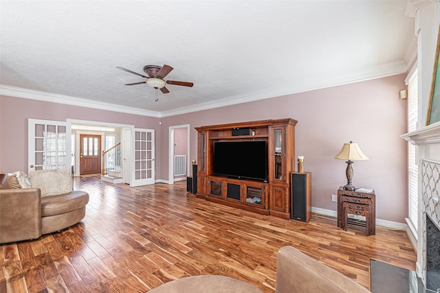 living room featuring ornamental molding, a fireplace, and wood-type flooring