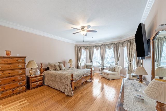 bedroom featuring ceiling fan, a textured ceiling, light wood-type flooring, and crown molding