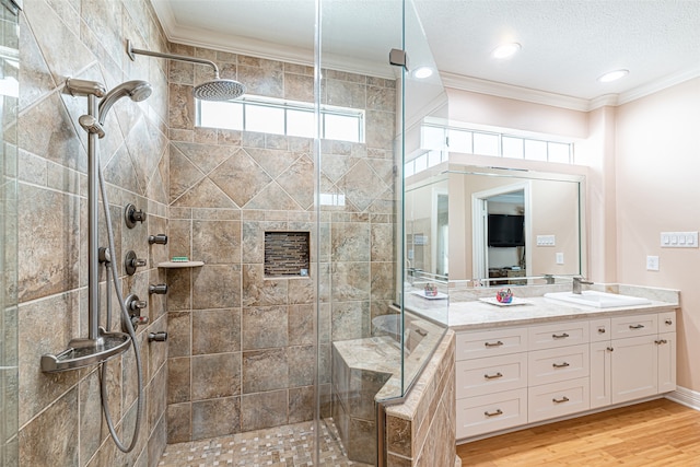 bathroom featuring crown molding, vanity, a textured ceiling, an enclosed shower, and hardwood / wood-style floors