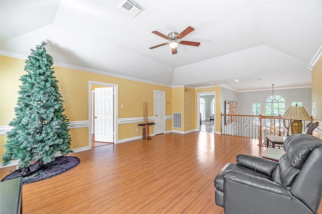 living room featuring lofted ceiling, ceiling fan, light wood-type flooring, and crown molding