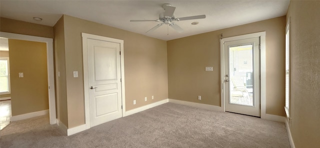 carpeted empty room featuring plenty of natural light and ceiling fan