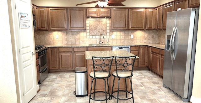 kitchen featuring sink, backsplash, a center island, a kitchen breakfast bar, and stainless steel appliances