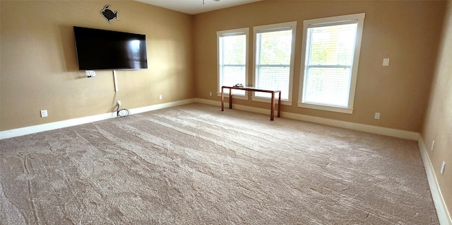 unfurnished living room featuring carpet and ceiling fan