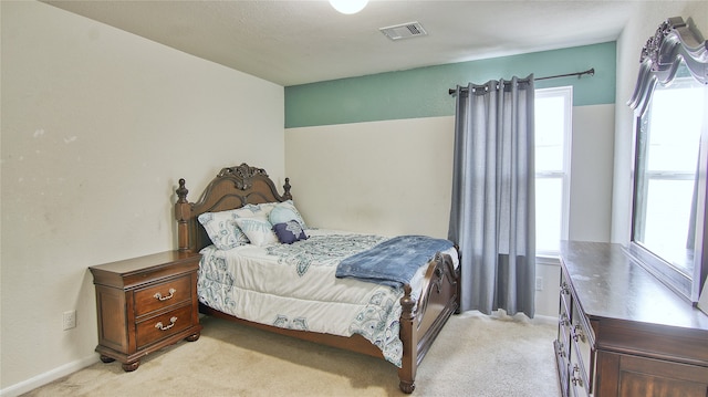 bedroom featuring a textured ceiling and light colored carpet