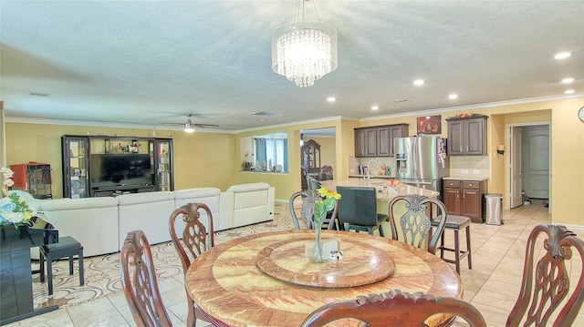 tiled dining space featuring crown molding, a textured ceiling, and ceiling fan with notable chandelier