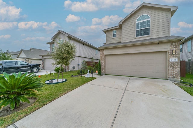 view of property featuring a garage and a front lawn