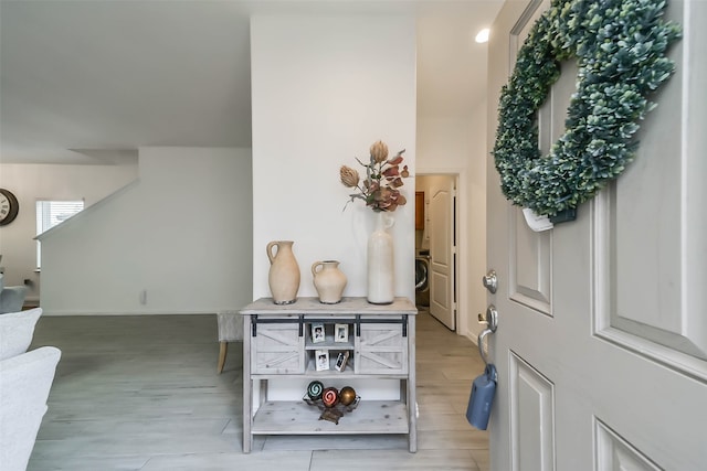 foyer with washer / dryer and light hardwood / wood-style flooring