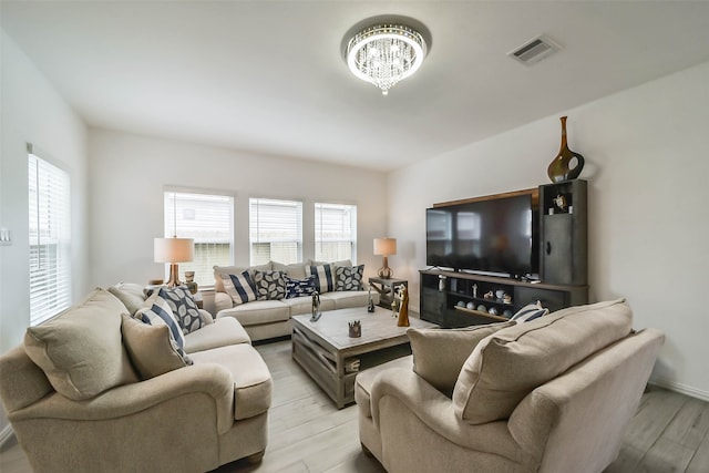 living room with a chandelier and light hardwood / wood-style flooring