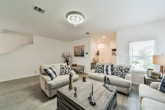 living room with wood-type flooring and a notable chandelier