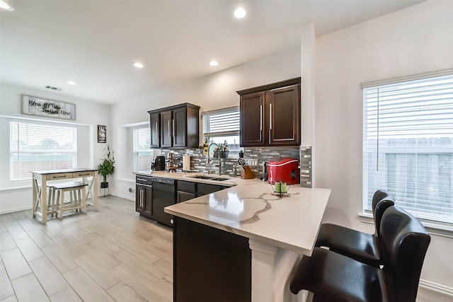 kitchen featuring decorative backsplash, plenty of natural light, sink, and a kitchen breakfast bar