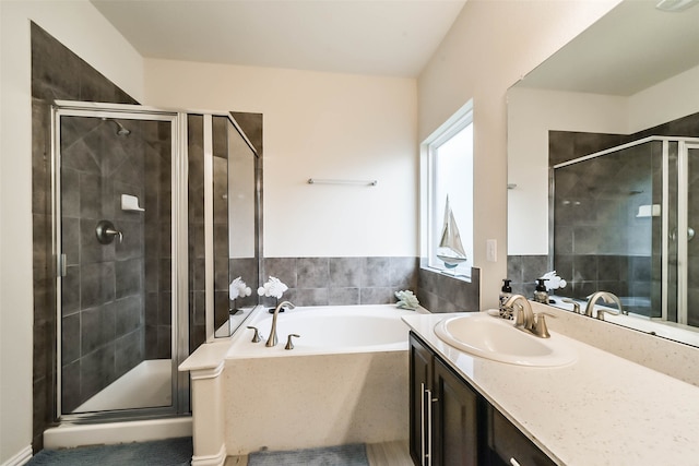 bathroom featuring vanity and independent shower and bath