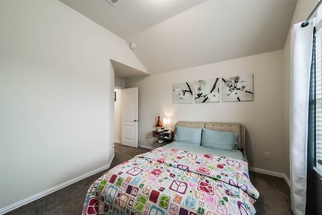 bedroom featuring dark colored carpet, lofted ceiling, and multiple windows