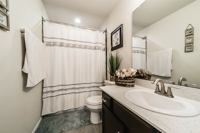 bathroom with hardwood / wood-style floors, curtained shower, vanity, and toilet