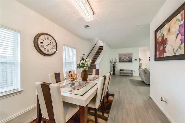 dining room with light hardwood / wood-style floors and a healthy amount of sunlight