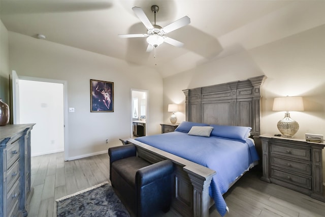 bedroom with light wood-type flooring, lofted ceiling, ceiling fan, and ensuite bath