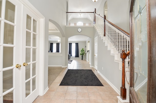 tiled foyer featuring french doors and a towering ceiling