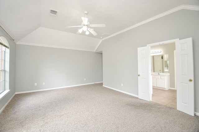 empty room with ceiling fan, light colored carpet, crown molding, and lofted ceiling