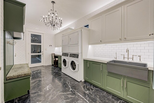 laundry room with washer and dryer, sink, brick wall, cabinets, and stacked washer and clothes dryer