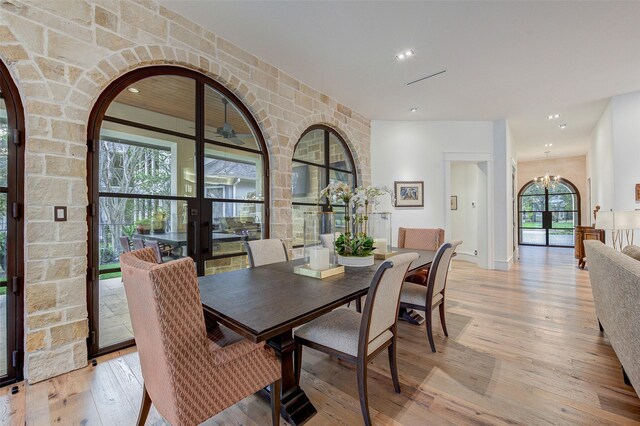 dining area featuring light hardwood / wood-style floors, french doors, and an inviting chandelier