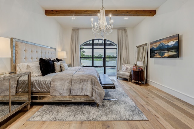 bedroom featuring beamed ceiling, hardwood / wood-style flooring, an inviting chandelier, and access to outside