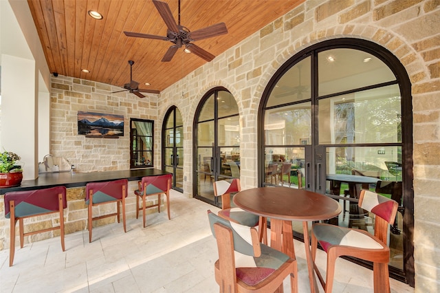 interior space featuring ceiling fan and exterior bar