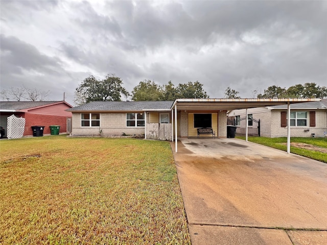 ranch-style home featuring a front lawn and a carport