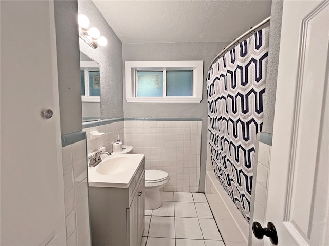 full bathroom featuring toilet, tile walls, vanity, shower / bathtub combination with curtain, and tile patterned flooring