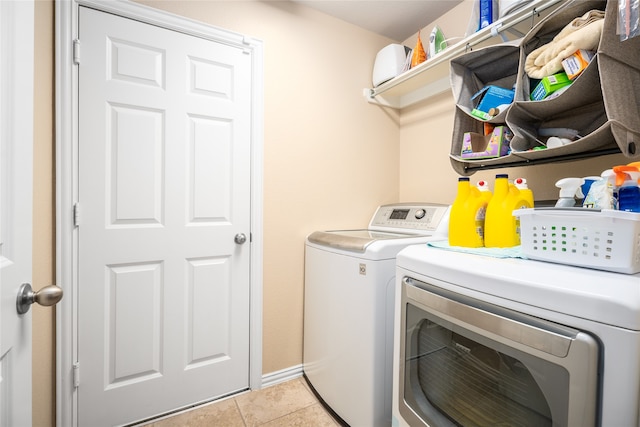 laundry room featuring light tile patterned flooring and separate washer and dryer