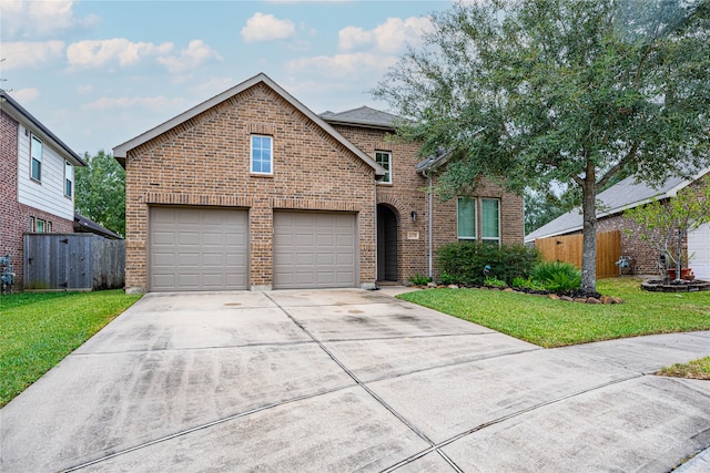 view of property featuring a garage and a front lawn