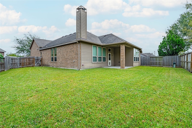 rear view of house with a patio and a yard