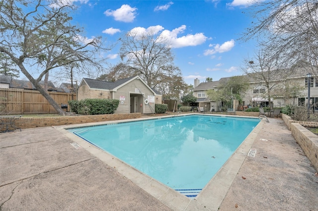 view of swimming pool with an outdoor structure and a patio area