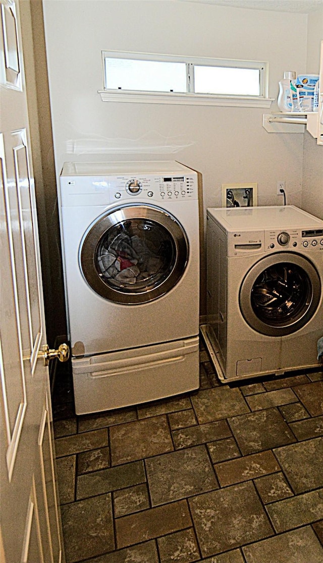 washroom with laundry area, brick floor, and washer and dryer