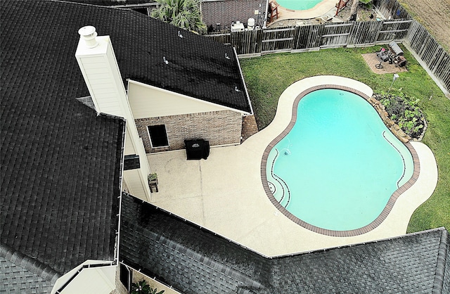 view of pool with a patio and a lawn