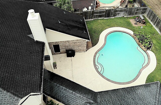 view of pool featuring a fenced in pool, a fenced backyard, a lawn, and a patio area