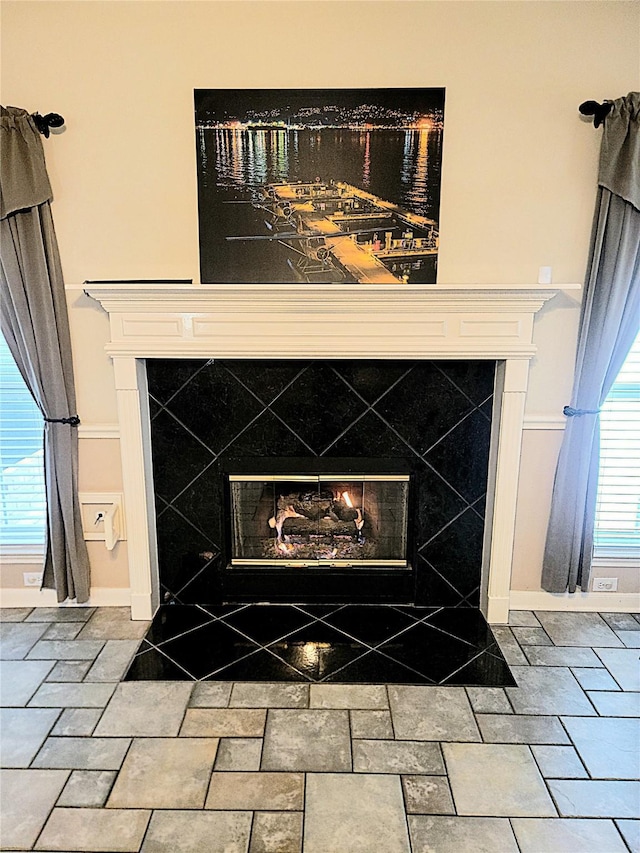 details with baseboards and a glass covered fireplace