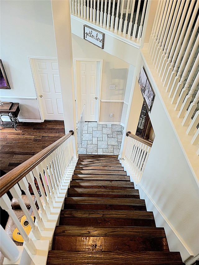 stairway featuring a high ceiling and hardwood / wood-style flooring