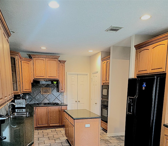 kitchen with recessed lighting, tasteful backsplash, visible vents, glass insert cabinets, and black appliances