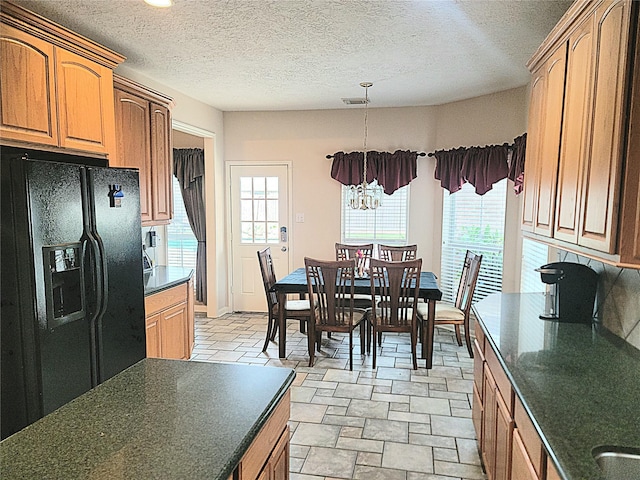 kitchen featuring a healthy amount of sunlight, dark countertops, and black refrigerator with ice dispenser