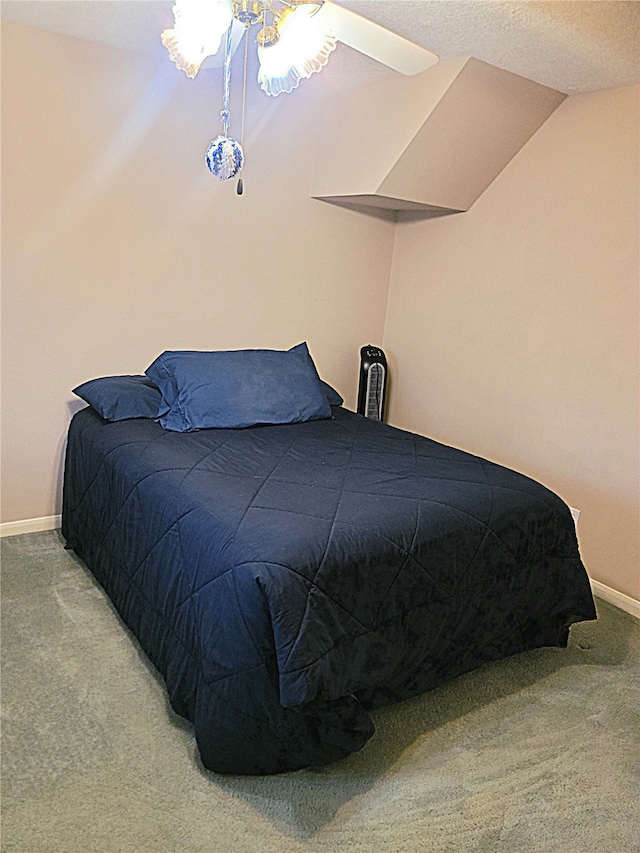 carpeted bedroom with vaulted ceiling, ceiling fan, and a textured ceiling