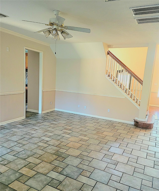 unfurnished living room with ceiling fan, baseboards, visible vents, ornamental molding, and stairway