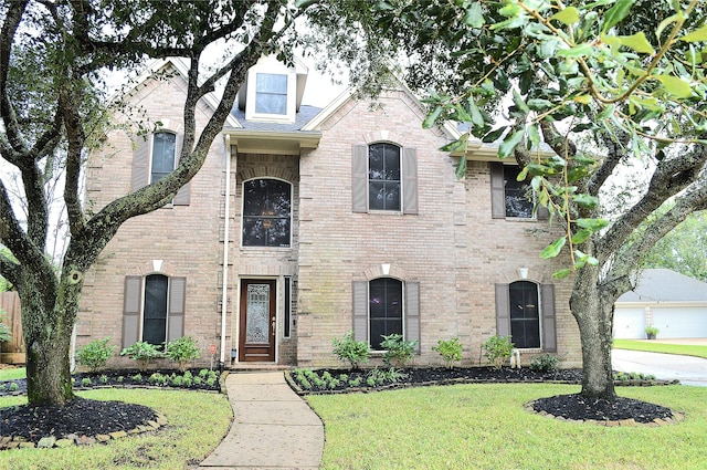 french country inspired facade with brick siding and a front yard