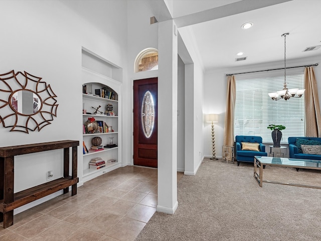 tiled foyer entrance featuring a notable chandelier