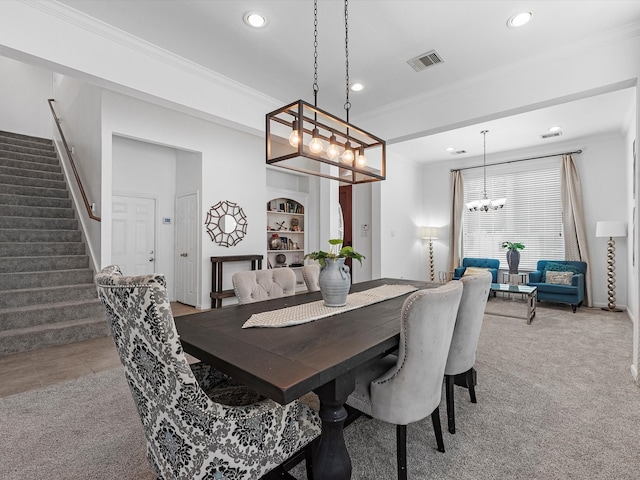 carpeted dining space with ornamental molding and a chandelier