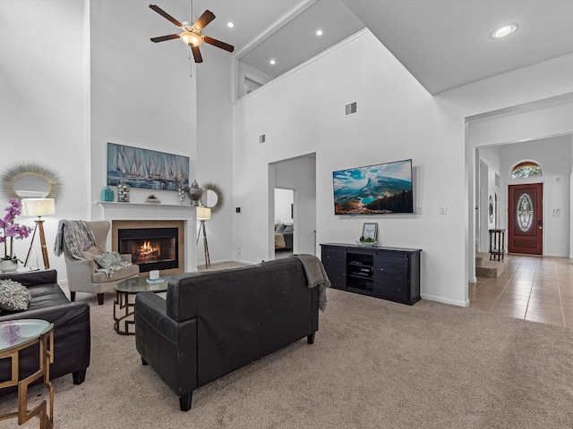 living room featuring a high ceiling, ceiling fan, and tile patterned flooring