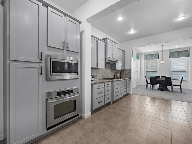 kitchen with backsplash, appliances with stainless steel finishes, light tile patterned flooring, gray cabinetry, and decorative light fixtures