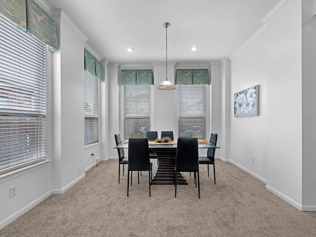 dining area with crown molding and light colored carpet