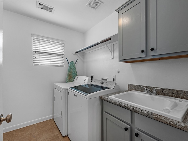 washroom featuring light tile patterned floors, cabinets, sink, and washing machine and clothes dryer