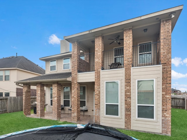 back of house with a patio, ceiling fan, a lawn, and a balcony