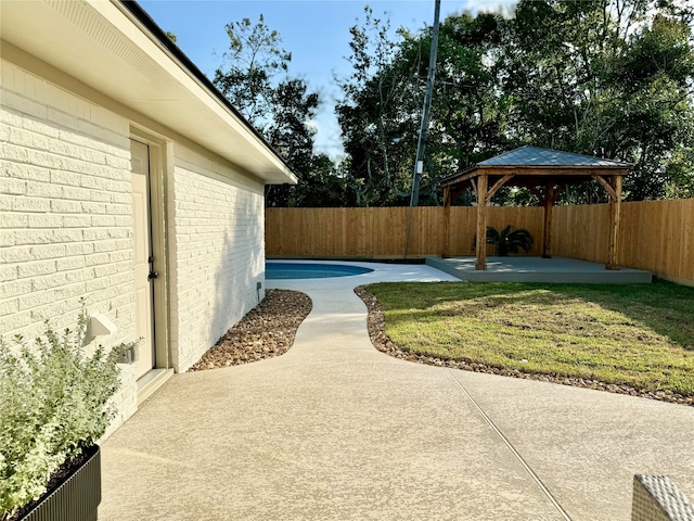 view of yard with a fenced in pool, a patio, and a gazebo