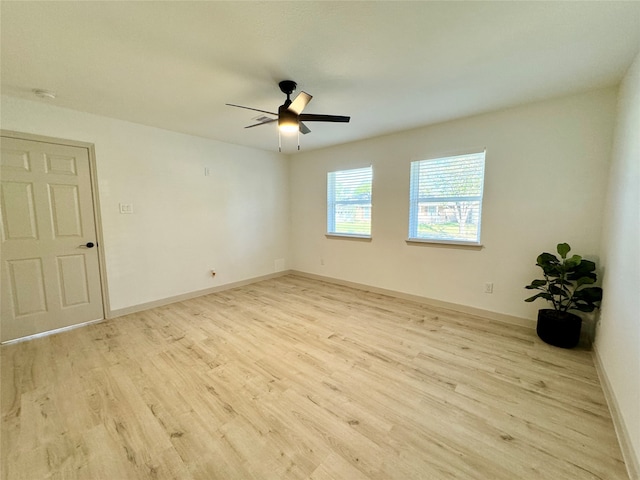 empty room with ceiling fan and light hardwood / wood-style flooring